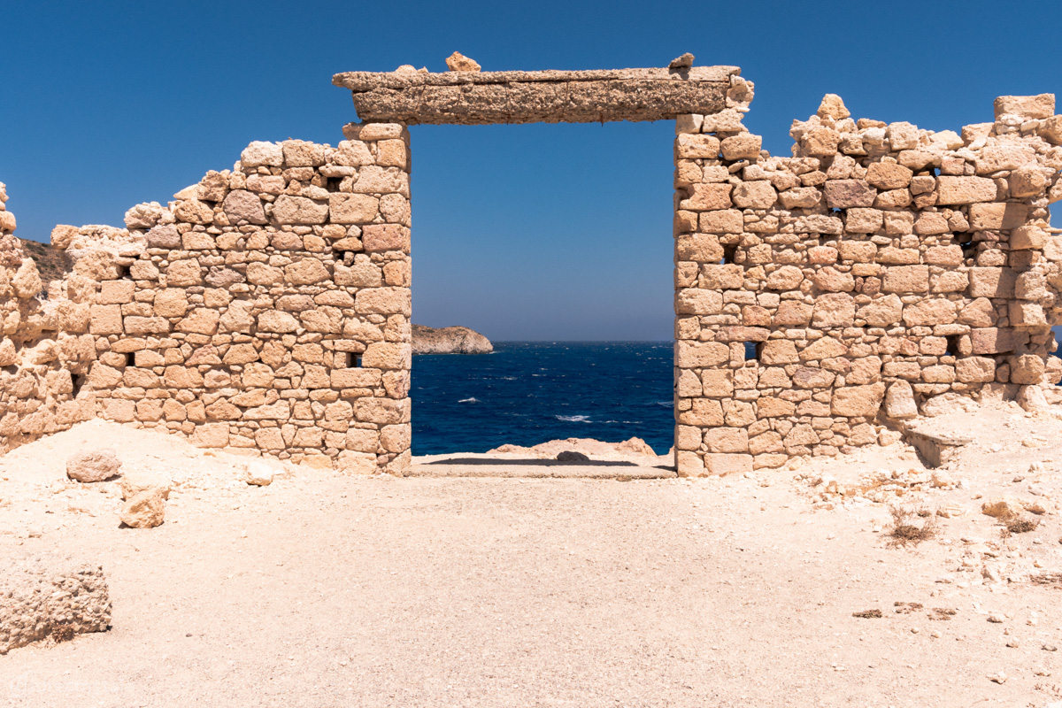 Door Ruins & Deep Blue Sea in Milos Island Stock Photo