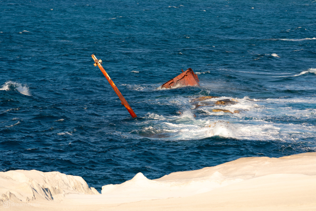 Half-Sunken Cargo Ship & Blue Sea Stock Photo